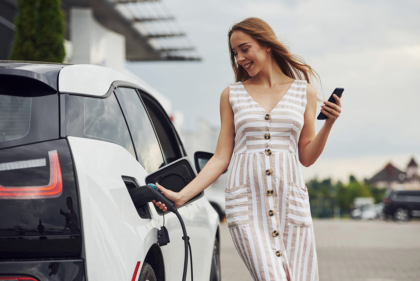 femme qui branche sa voiture electrique